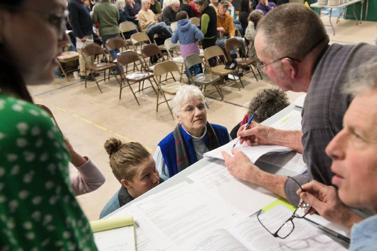 A group of people standing at a table in a room.