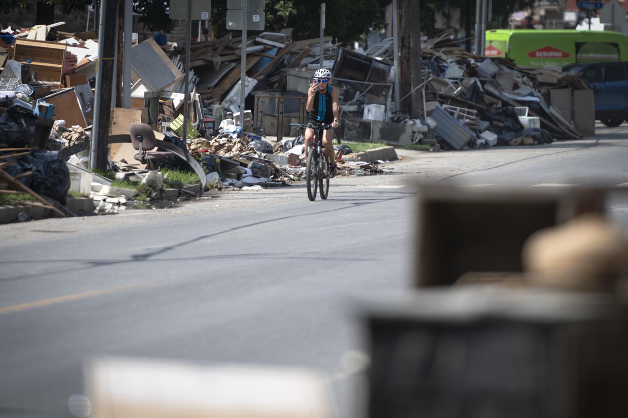 a person riding a bike down a street full of rubble.