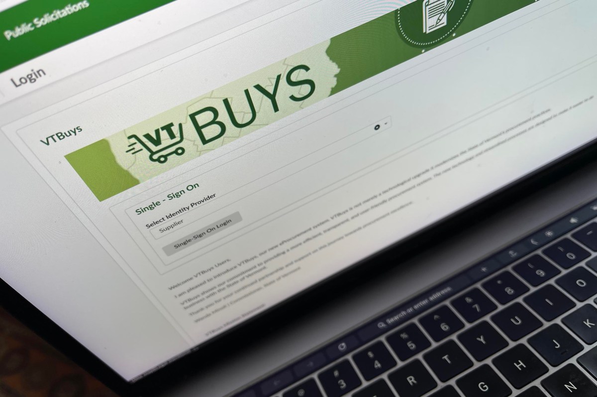 A close-up of a laptop screen displaying the VTBuys login page for single sign-on, with a green header and login options.