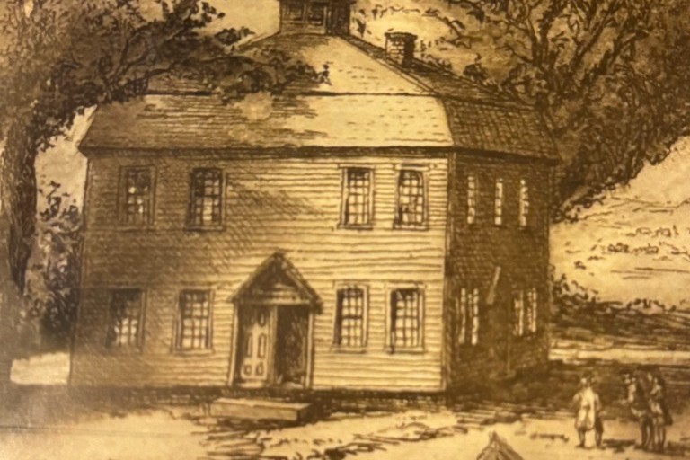 A sepia-toned illustration of a two-story wooden house with multiple windows. Two people stand in front, and large trees loom in the background.