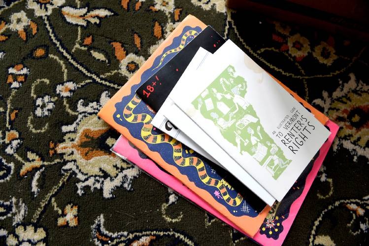 A stack of books and booklets, including one titled "A Tenant’s Guide to Understanding Renter’s Rights," lies on a patterned carpet.